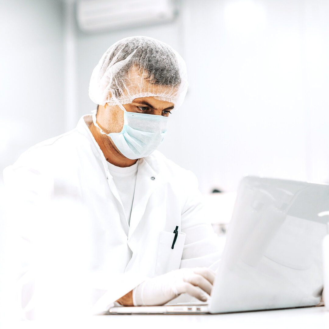 side view of man on laptop inside a lab